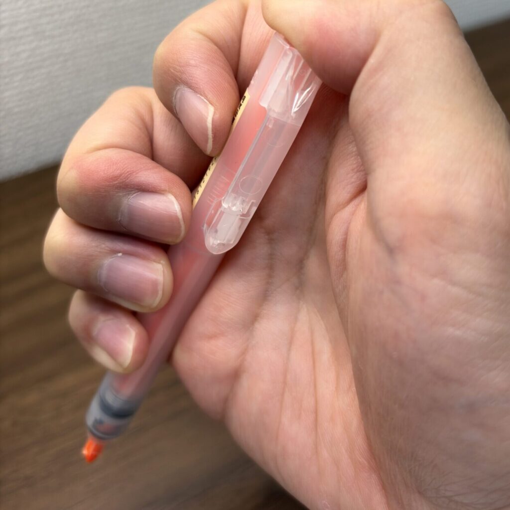 親指でノックしてペン先を出したノック式蛍光ペン